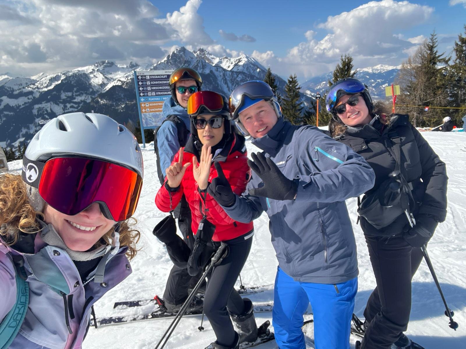 Leden van Rotary Club Amersfoort Young Ambition op de piste in Flachau met besneeuwde bergen op de achtergrond