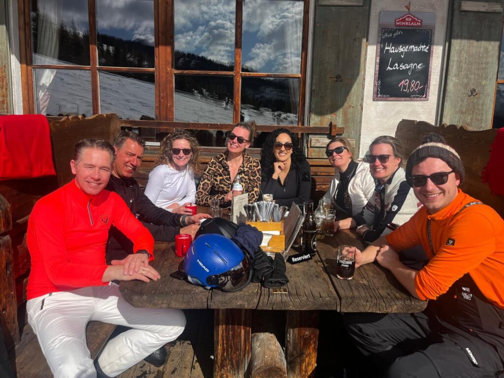 Acht RAYA-leden op het terras van Berghut Winklalm tijdens de wintersport in Flachau