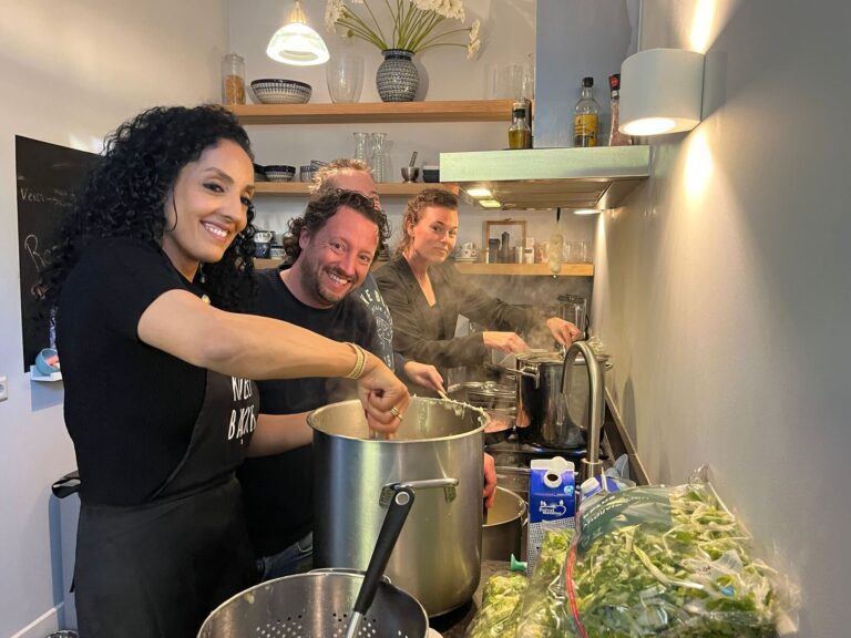 Leden van Rotary Club Amersfoort Young Ambition lachend tijdens het koken van hutspot en andijviestamppot voor Motiva Straatadvocaten