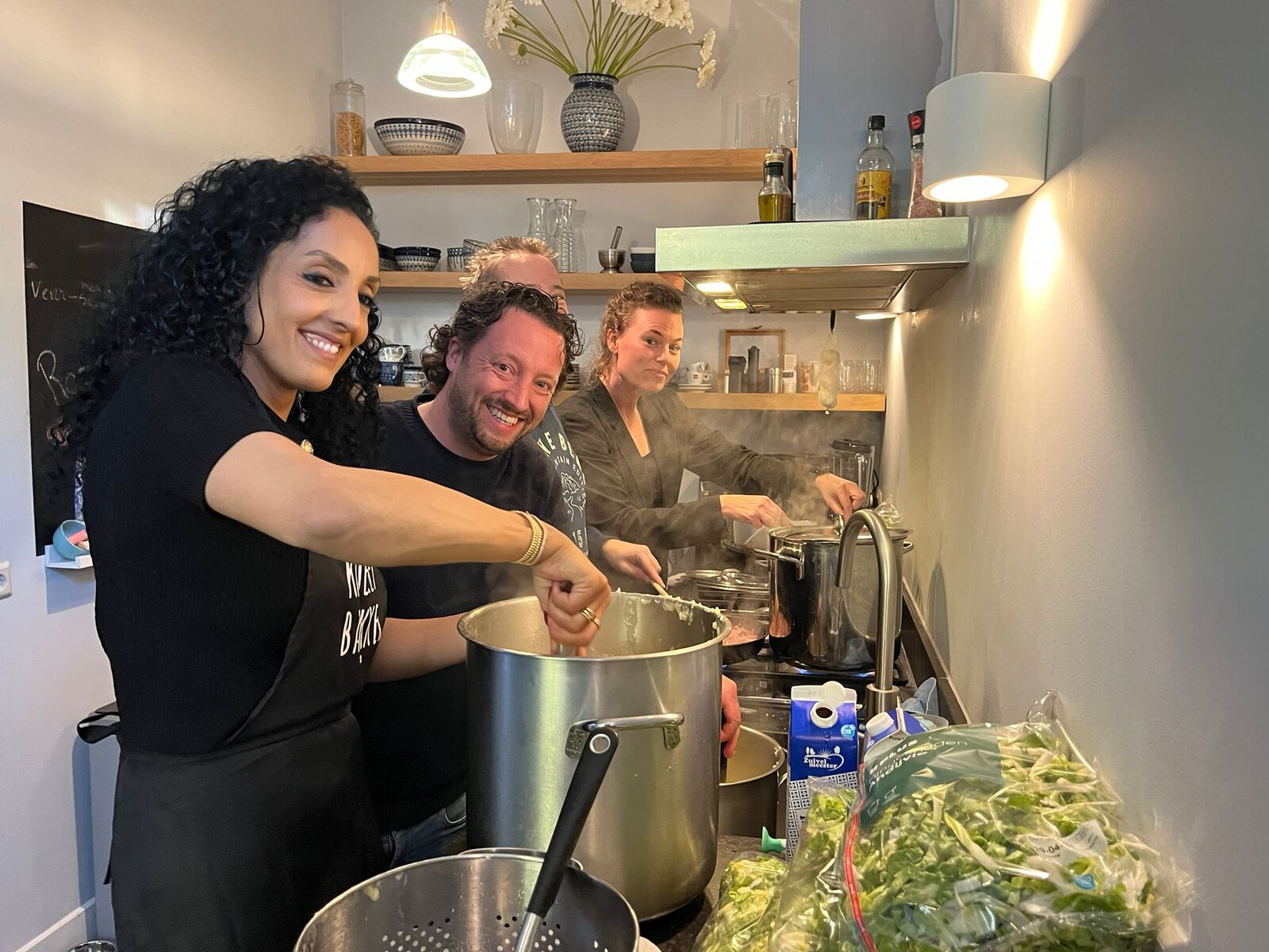 Leden van Rotary Club Amersfoort Young Ambition lachend tijdens het koken van hutspot en andijviestamppot voor Motiva Straatadvocaten